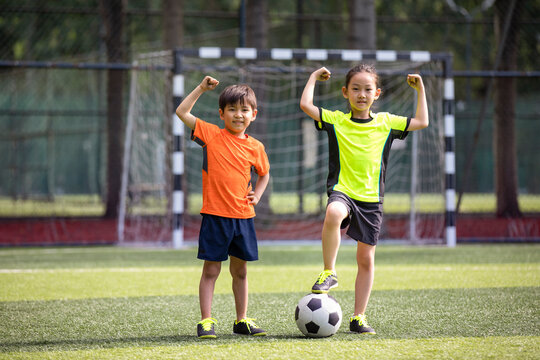 Happy children playing football on field
