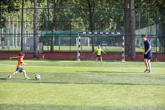 Father and children playing football on field