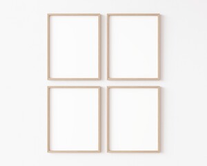 Four empty vertically oriented rectangular picture frames with thin wooden border hanging matrix-arranged on white wall. 3D illustration.