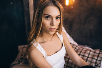 portrait of a pretty girl in a white T-shirt in the room