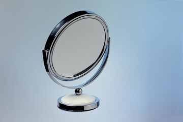 A makeup mirror on a colored background closeup