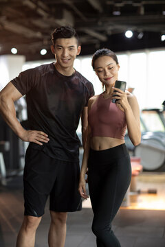 Young couple taking selfie with smartphone at gym