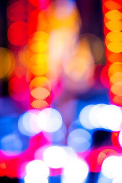Cozy evening in the festive city. Blurred image of Shining Christmas lights, light garlands for Christmas and New Year celebration time at midnight. Abstract holiday or circus  background.