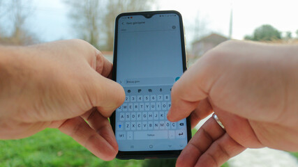 Hands holding mobile smart phone. Writing message to simeone. Free message 