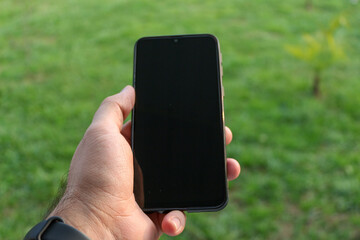 hand holding phone. Black screen view. 