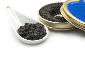 Fototapeta na wymiar Closeup of caviar in a white ceramic spoon with the metalllic box on white background