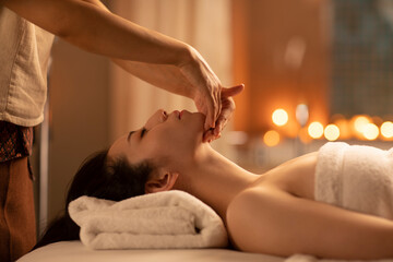 Young woman receiving facial massage at spa center