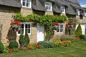 Traditional English thatched cottage with colourful garden