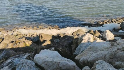 Dangerous sea foam on the rocky shoreline -wide
