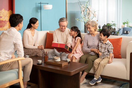 Young couple giving gift to their parents