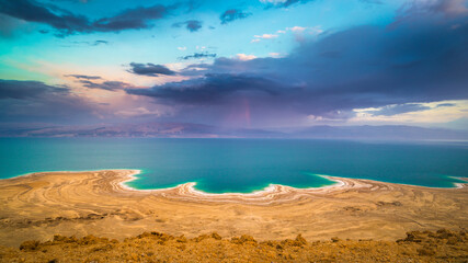 Beautiful Israeli landscape: rainbow in the clouds over the Dead Sea, the lowest place on Earth, its north-western shore covered in sinkholes