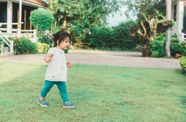 Asian baby girl playing on playground and having fun in park