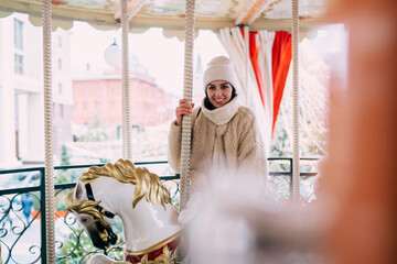 Cheerful woman on illuminated carousel