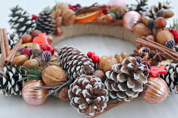 Handmade Christmas wreath of pine cones, oranges, nuts, and beads