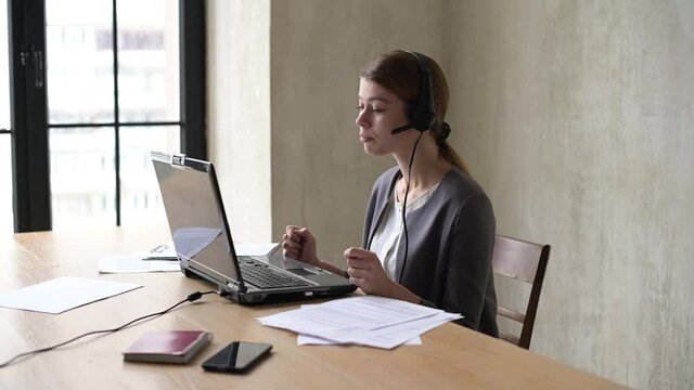 A young office worker leads a virtual meeting via webcam. Remote virtual consultations, negotiations, interviews