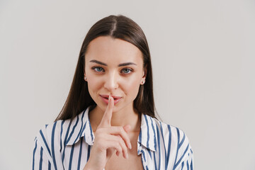 Happy beautiful brunette girl smiling and showing silence gesture