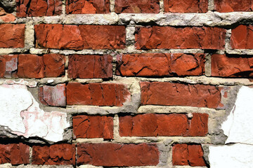 Wall of old destroyed bricks with remains of plaster, vintage background