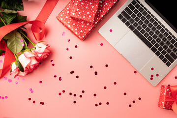 top view of valentines day workspace with laptop keyboard, flowers and gift boxes