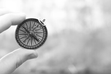 Classic navigation compass in hand on smoke background as symbol of tourism with compass, travel...