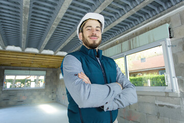professional repairman posing and apartment under renovation