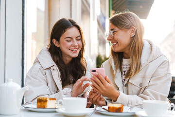 Two young girls using smart phone