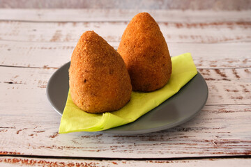 Large tasty fried balls made with rice, meat and peas called ARANCINI DI RISO in the Italian language