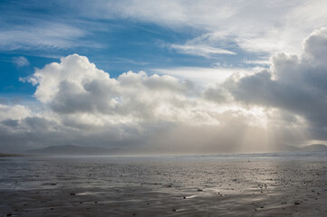 Sun rays and dark clouds above Inch Beach, Irleand with ring of Kerry mountains background. Panoramic seascape in Ireland. Concepts: season, outdoors, travel, landscape