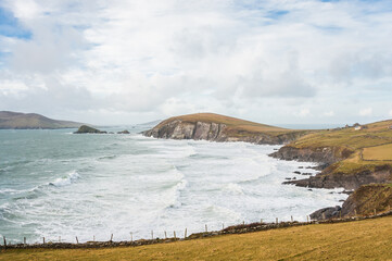 Scenic landscape with atlantic ocean shore, mountain hills and picturesque village houses during winter autumn season in Ireland. Concepts: season, outdoors, travel, landscape