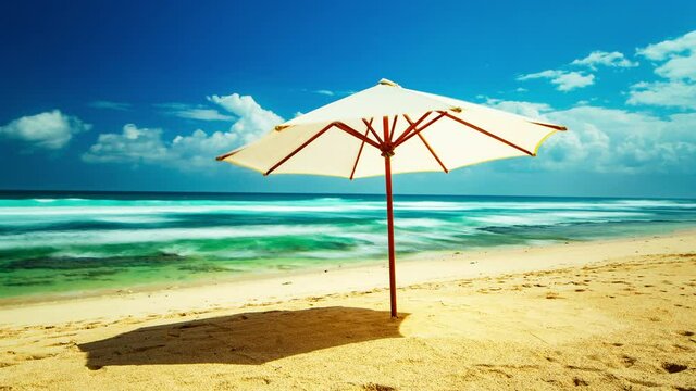 Beautiful wild beach by the ocean with a beach umbrella, yellow sand and clear blue water. 4K time lapse.