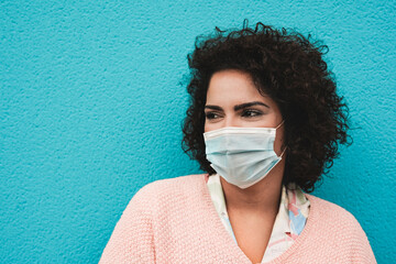 Happy young woman wearing surgical face mask for coronavirus