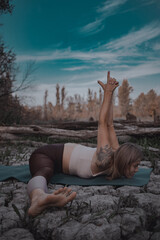 attractive blonde doing yoga outdoors in an unusual place