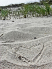 Fototapeta na wymiar Heart in White Sand and Dune. a clear summer day on the island of Ruegen
