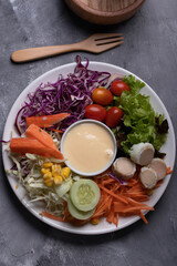 Mixed green salad, thick dressing in white plate