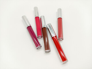 Group of multicolored liquid lipsticks on a white background close up