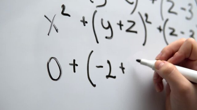 Writing mathematics on whiteboard close up. Math lesson, education concept