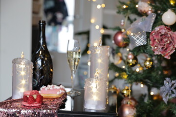 Three candles with stars, bottle of wine with glass of champagne, Christmas tree, xmas time decoration