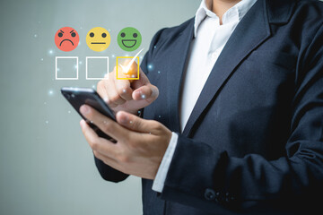 Businessmen, men using smartphones, choose ratings feedback, product satisfaction, or service chooses an icon who is very happy and highly satisfied, evaluating experience.