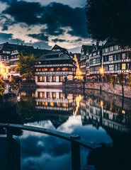 the beautiful Strasbourg in the evening with reflection on the water and beautiful half-timbered houses with flowers. City panorama