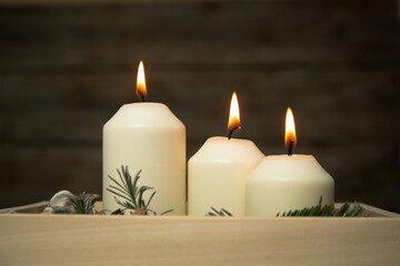 Fototapeta na wymiar Wooden box christmas centerpiece. Simple and small home decoration with candles in wooden box. 