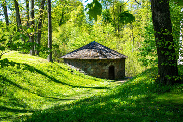 Latvia - Round stone building in a green grove among the trees, near the Cesvaine castle, in the summer during the day.
