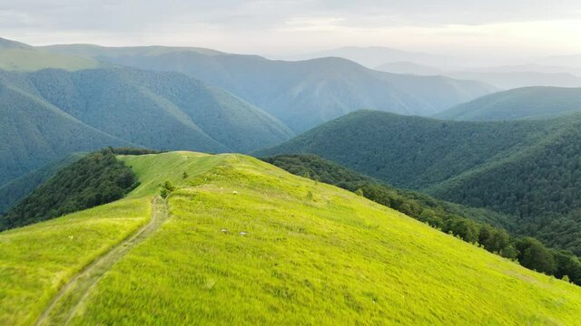 Magic sunrise in summer Carpathian mountains from fliying drone. Misty mountain valley and hight peaks on background. UHD 4k video