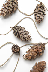Simple and natural pinecone garland on white. Budget-friendly DIY fall decorating ideas. 