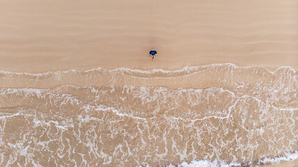 
The top view of a beautiful beach with a woman is standing.
