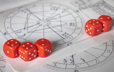 Red dice on printed astrology  natal chart , close up, destiny and fortune concept
