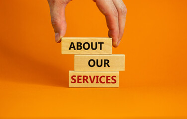 About our services symbol. Wooden blocks tower with words 'about our services'. Male hand. Beautiful orange background. Copy space. Business and about our services concept.