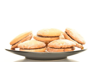 Shortbread biscotti with white ceramic dishes, close-up, on a white background.