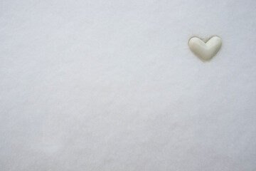 The white heart on the snow with copy space. Winter background and texture. 
