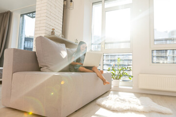 Little girl studying online using her laptop at home