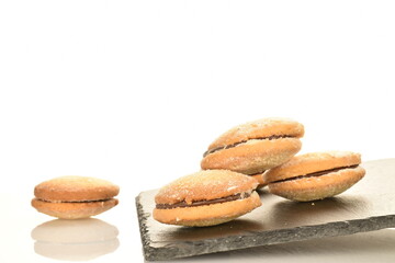Several delicious biscotti shortbread cookies on a serving slate board, close-up, isolated on white.