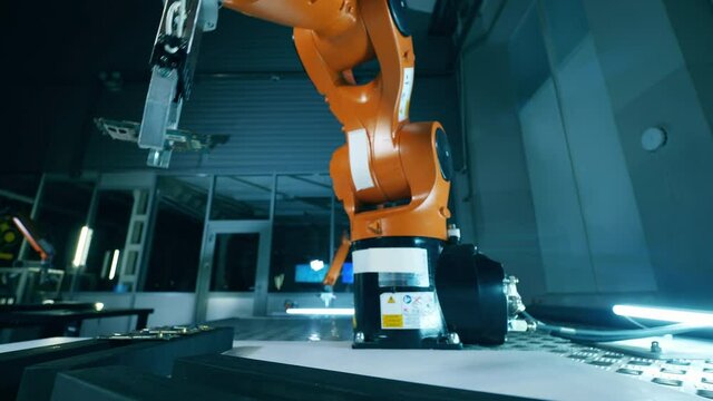 Low angle view of Kuka robot manipulations with microchip